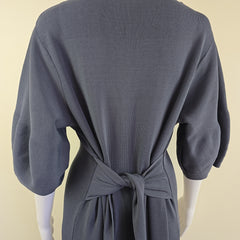 Dark gray dress with a bow detail on a beige background