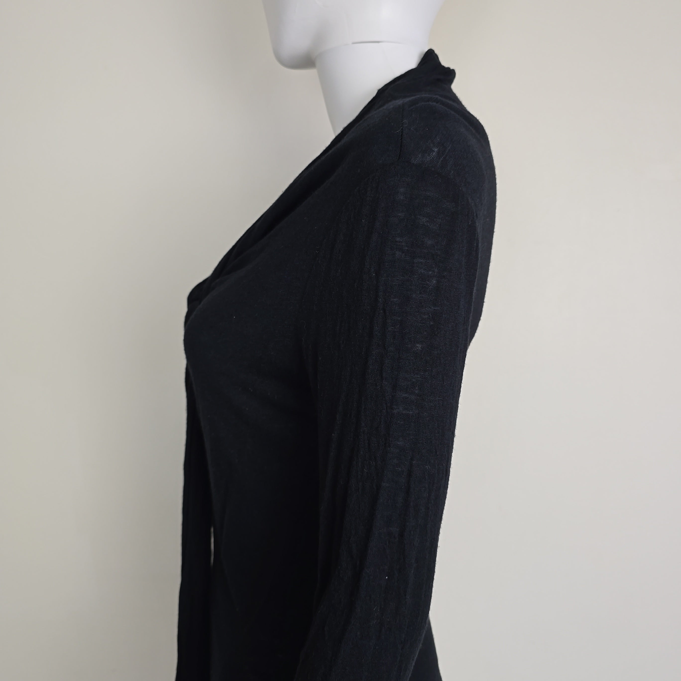 Black top with tie detail on a light background