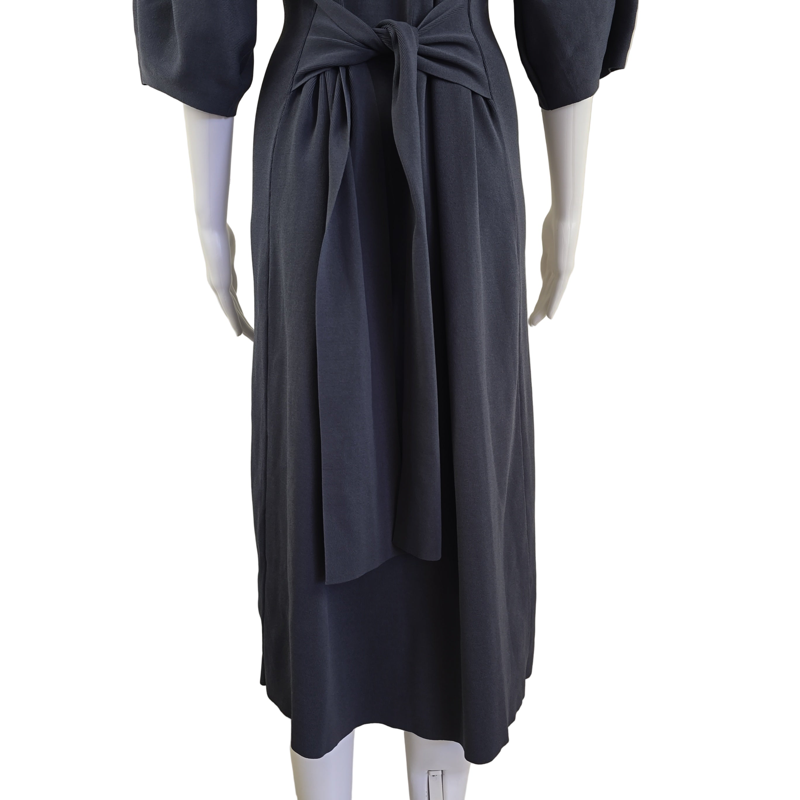 Grey dress on a mannequin against a beige wall