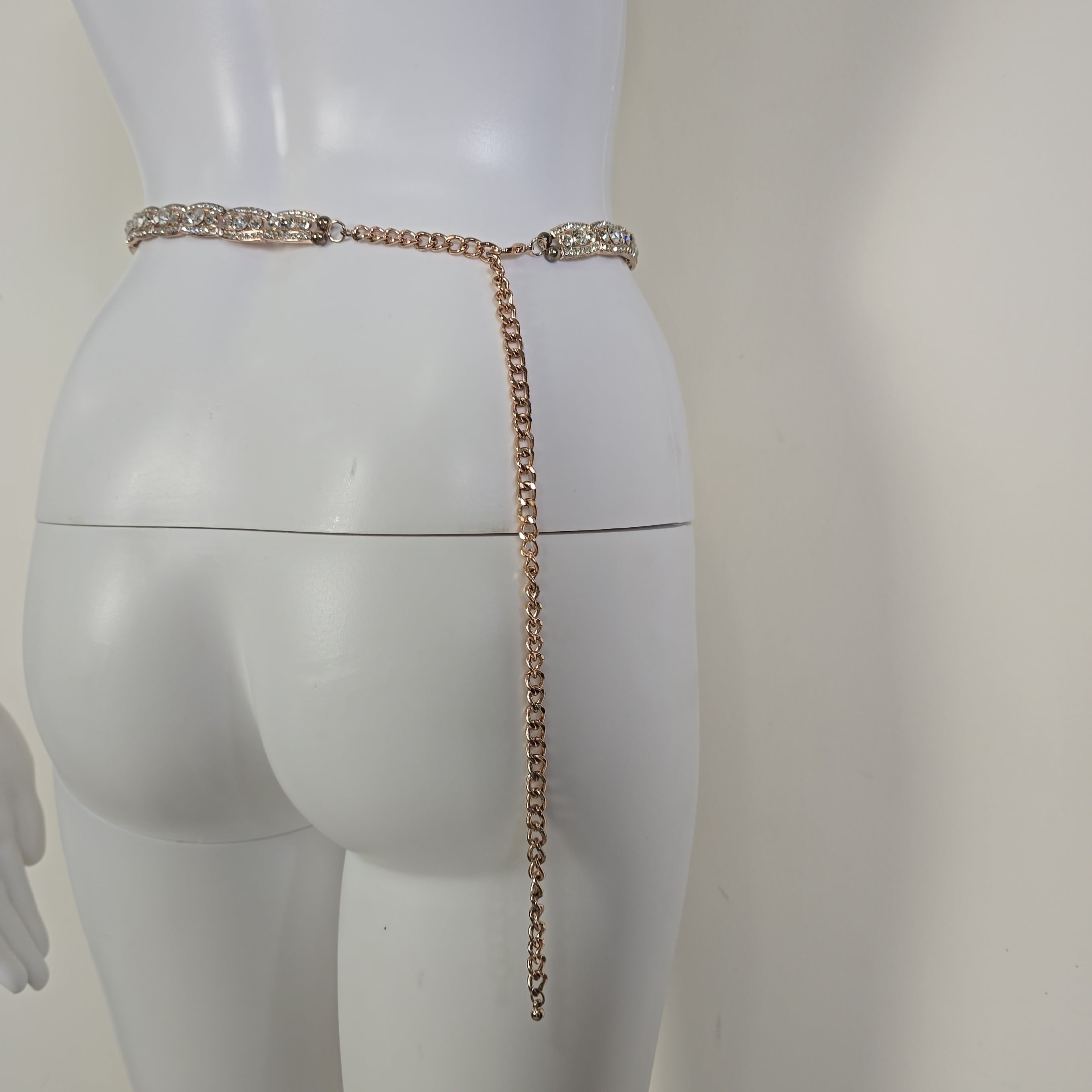Rose gold belt with crystals on a white mannequin