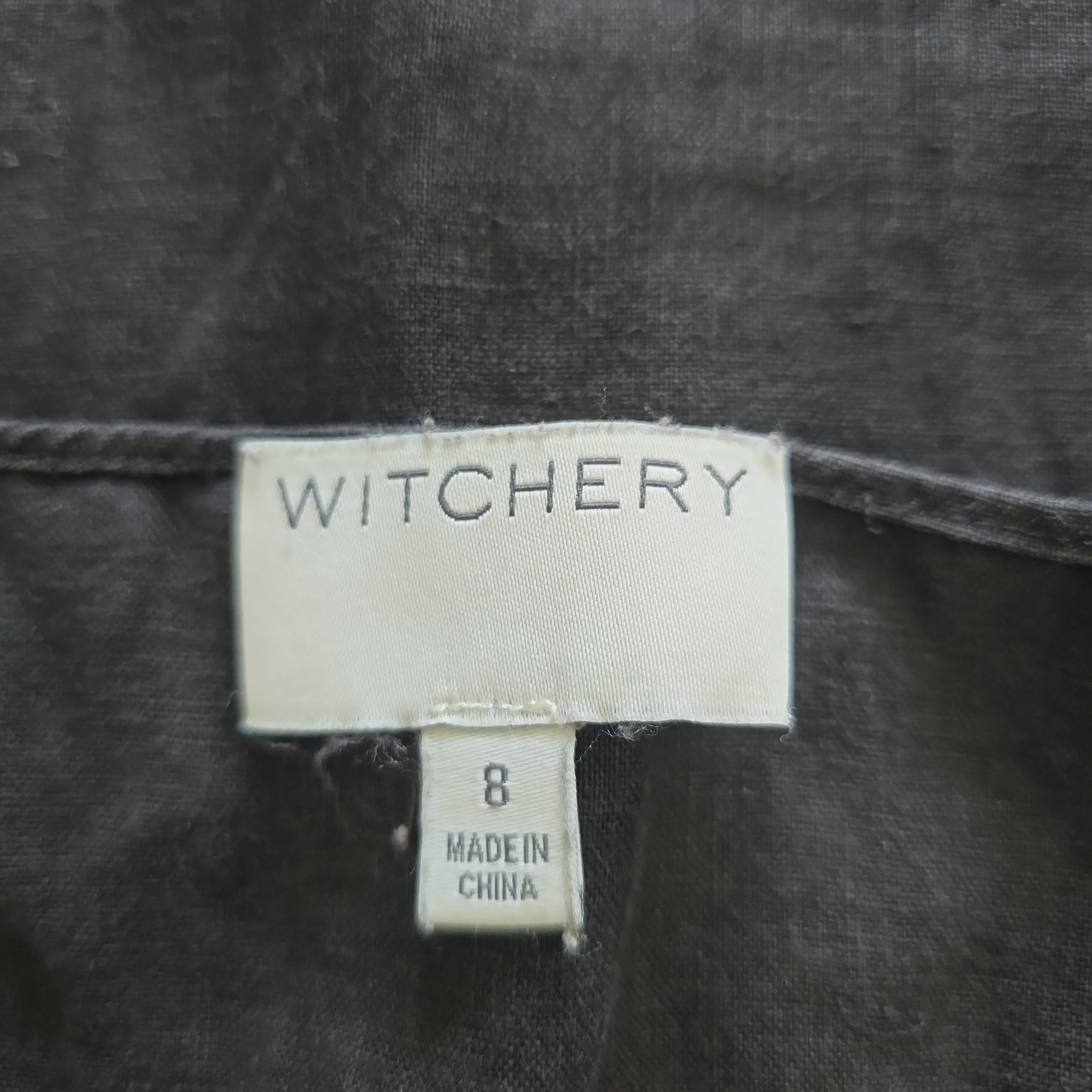 Witchery label on a dark fabric background