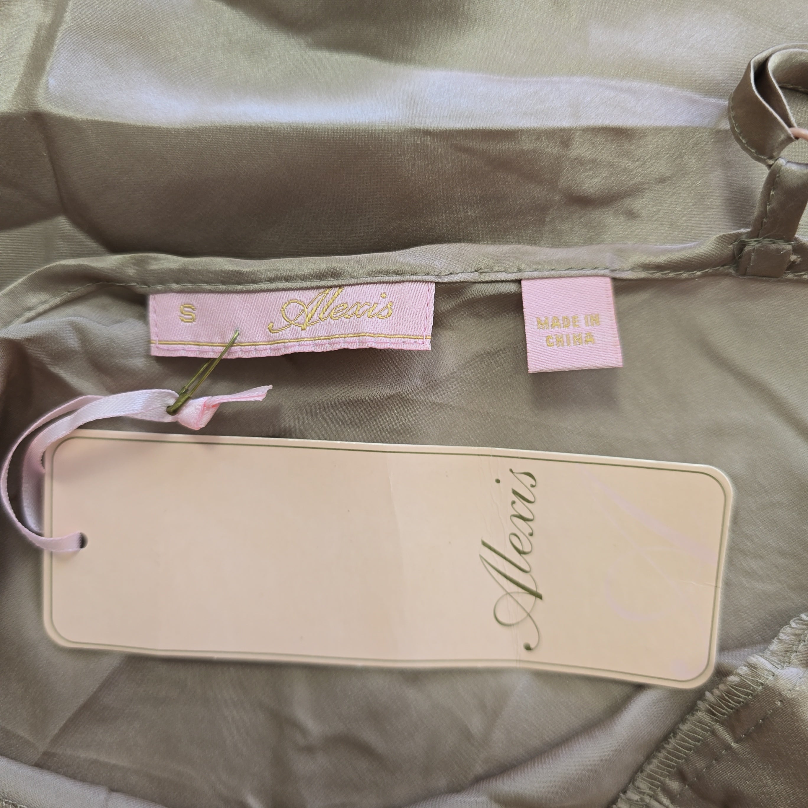Alexis brand and size tag on beige silk background