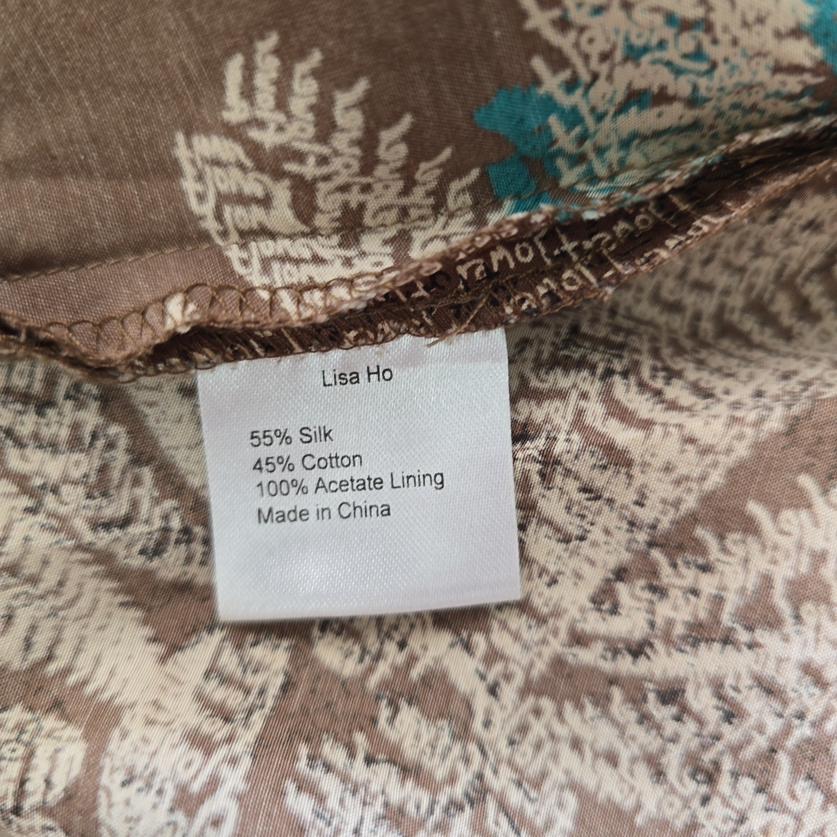 Close-up of a fabric label on a patterned garment with 'Lisa Ho' branding.