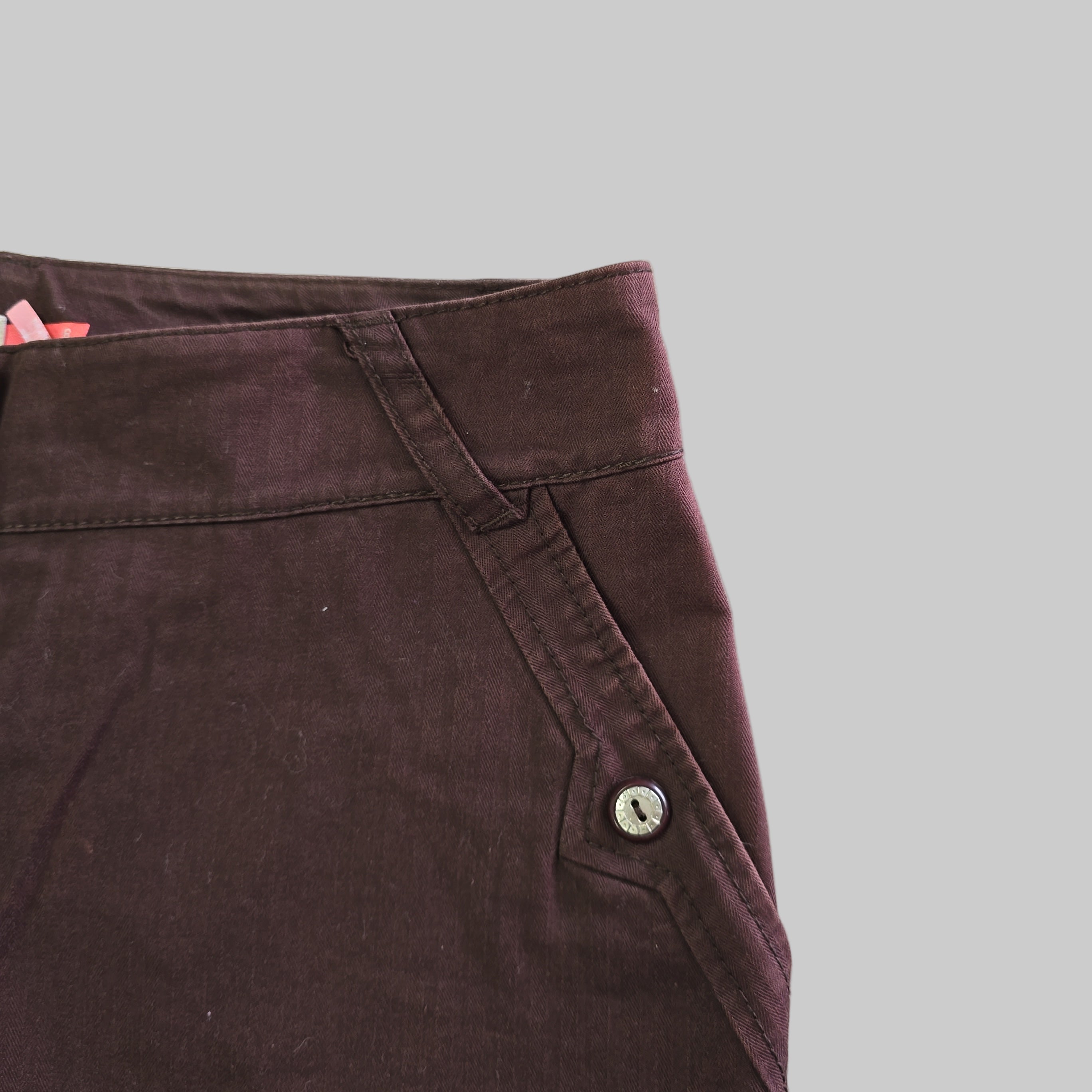 Close-up of a brown fabric with a button on a light gray background