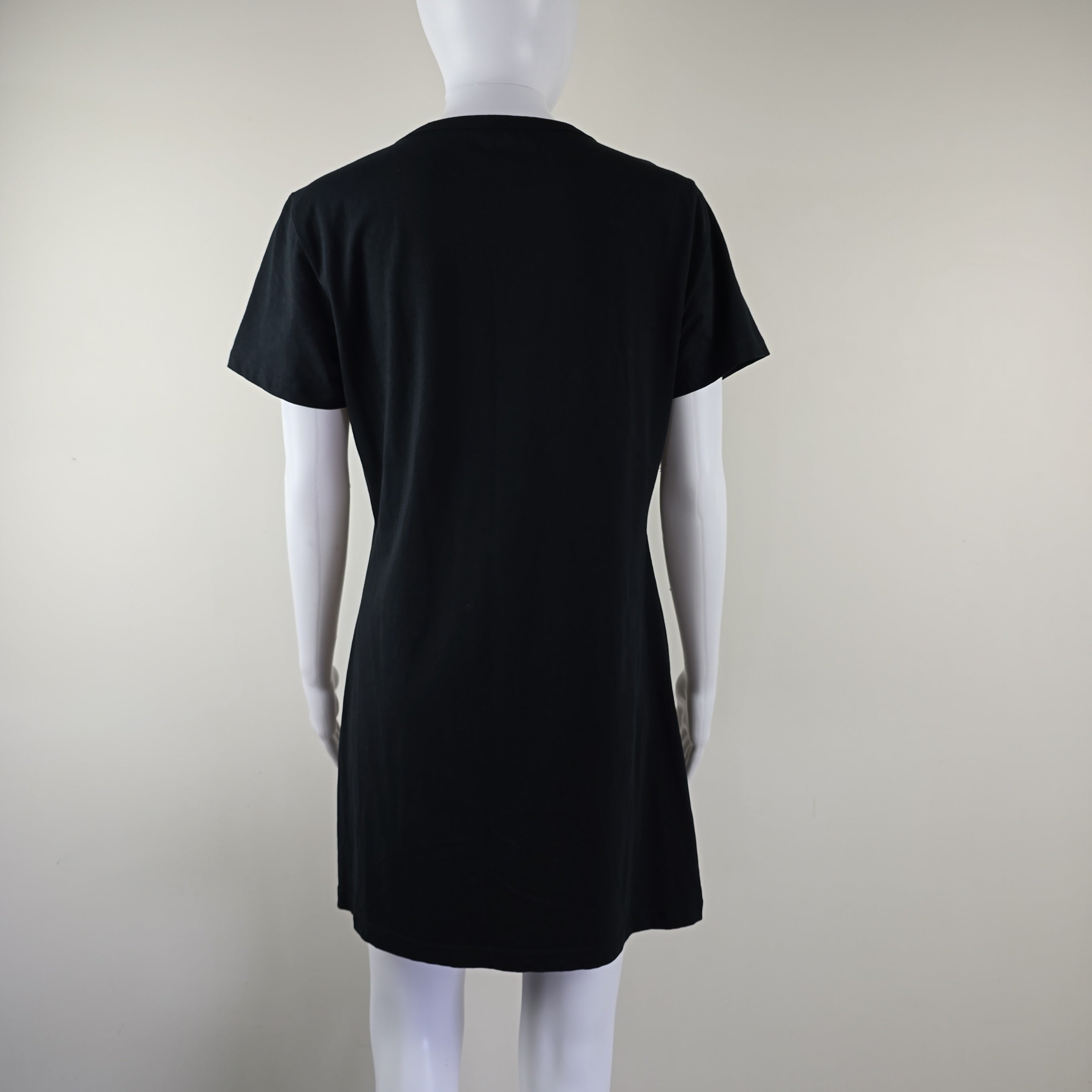 Black dress on a white mannequin against a light gray background
