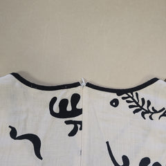 White apron with black floral patterns on a beige background