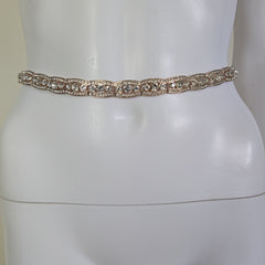 Gold belt on a mannequin against a white background