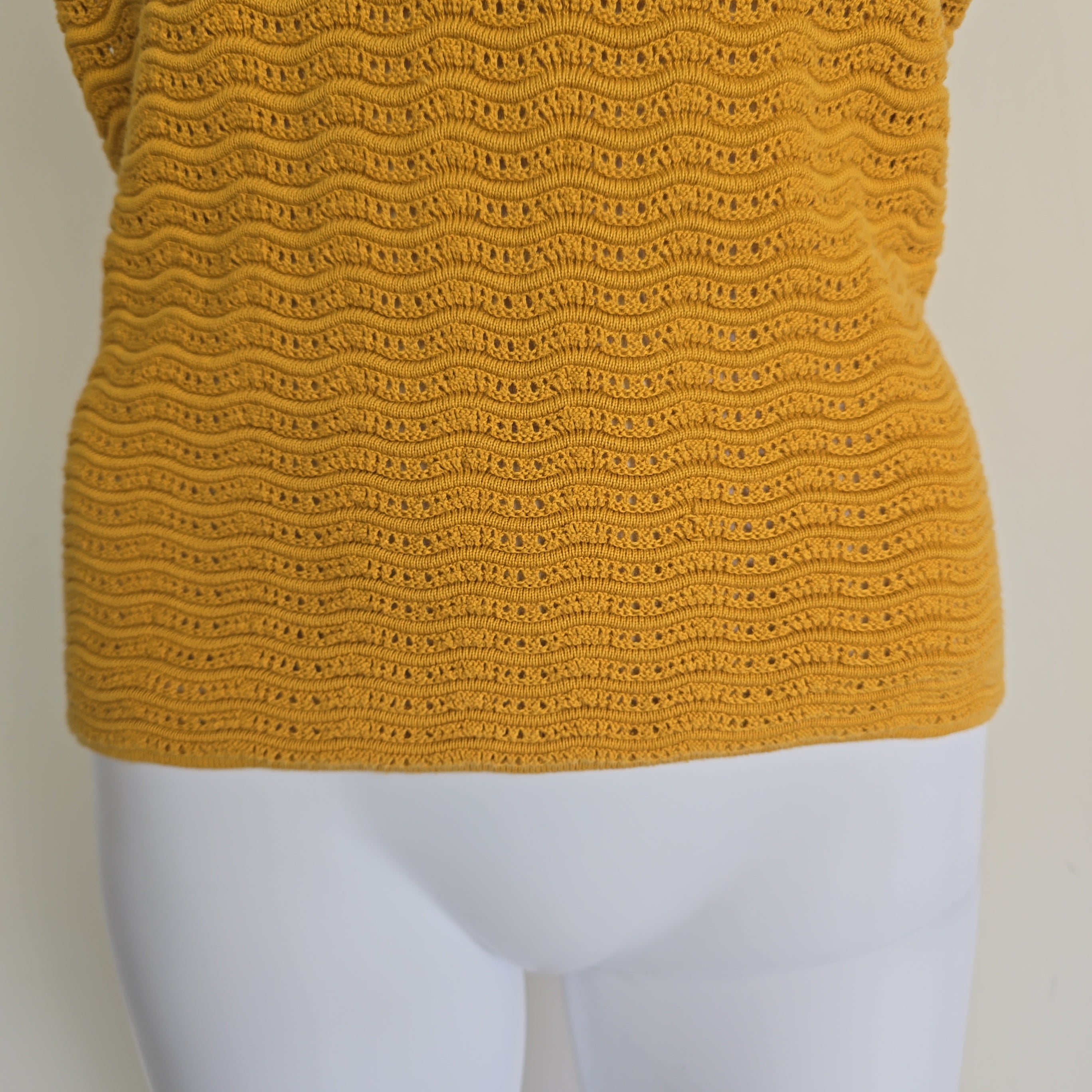 Close-up of a yellow textured fabric on a mannequin.