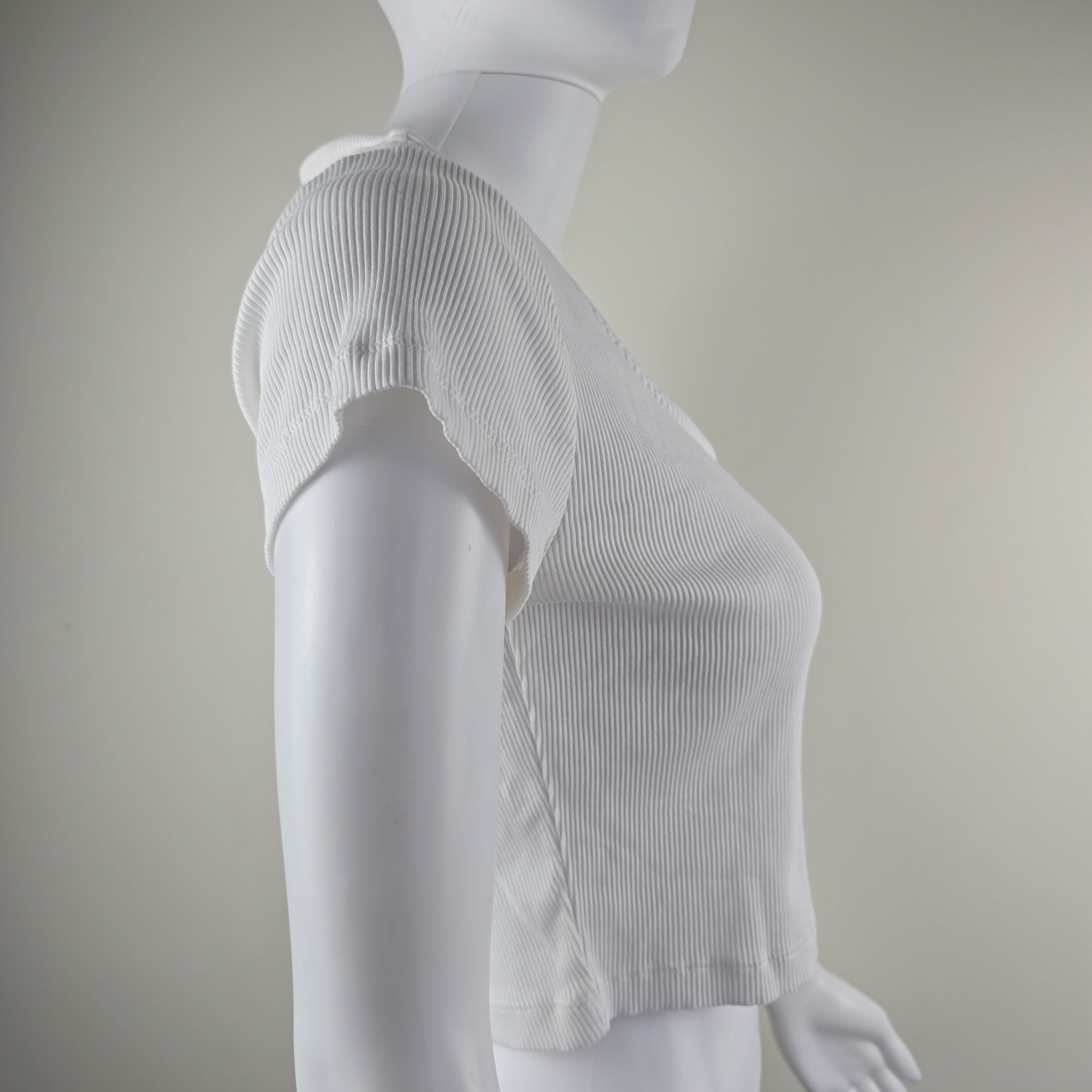 White mannequin with a textured top on a plain background