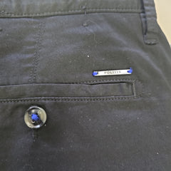 Close-up of a dark fabric surface with a button and label.