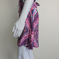 Mannequin wearing a colorful patterned dress with a plain background