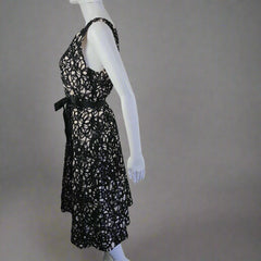 Black lace dress on a mannequin against a white wall