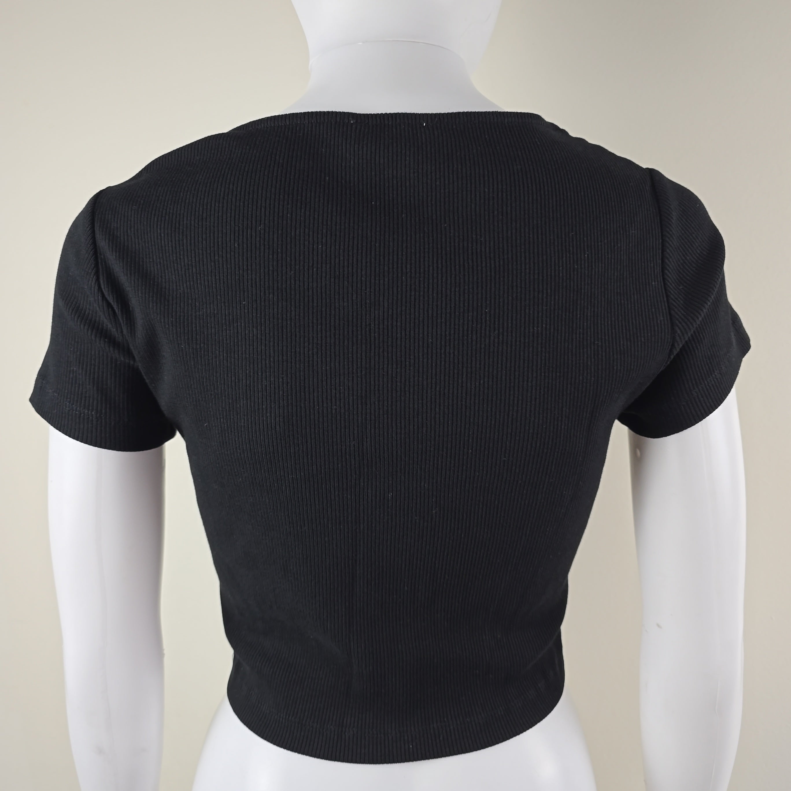 Black top on a white and beige background