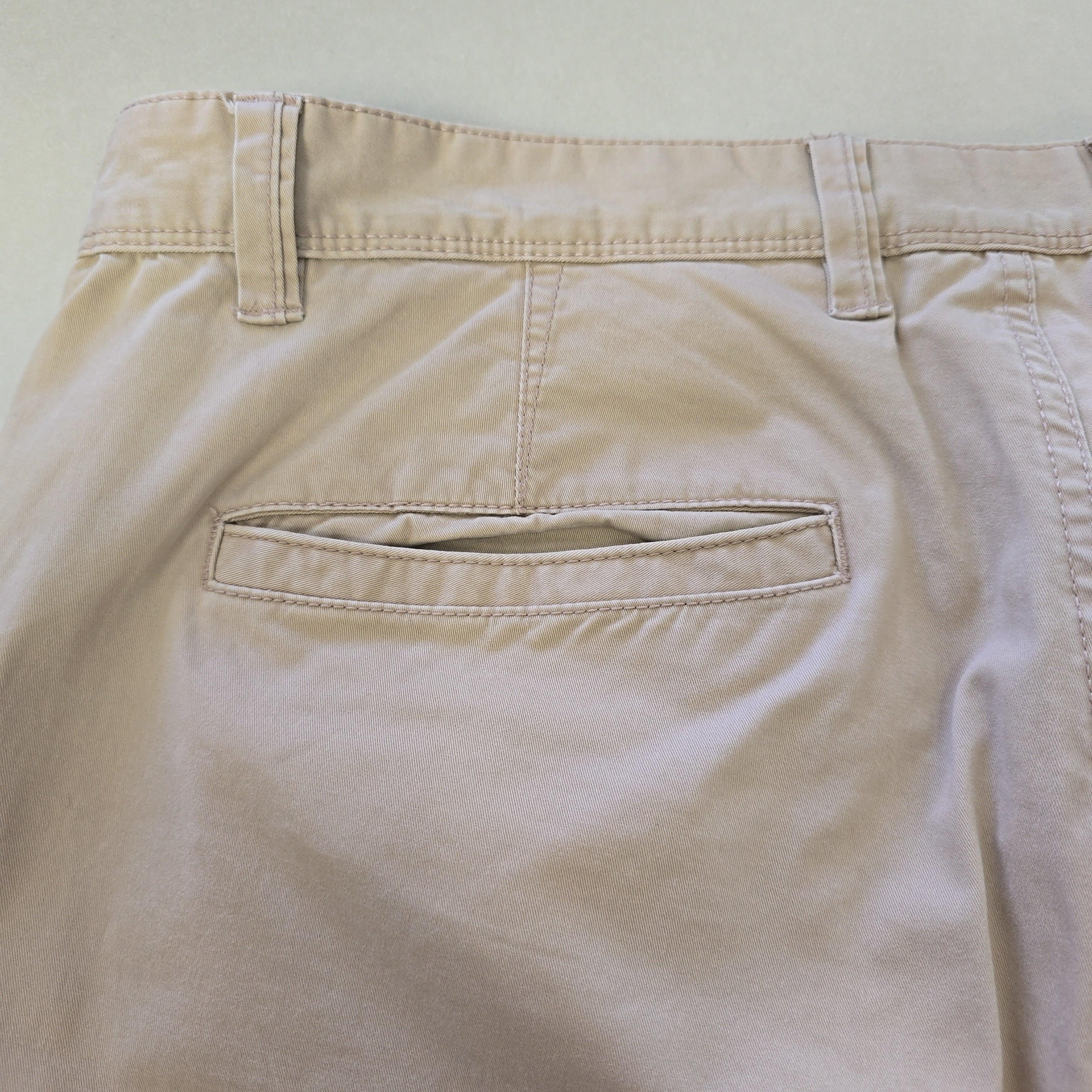 Close-up of beige pants with a pocket on a light background