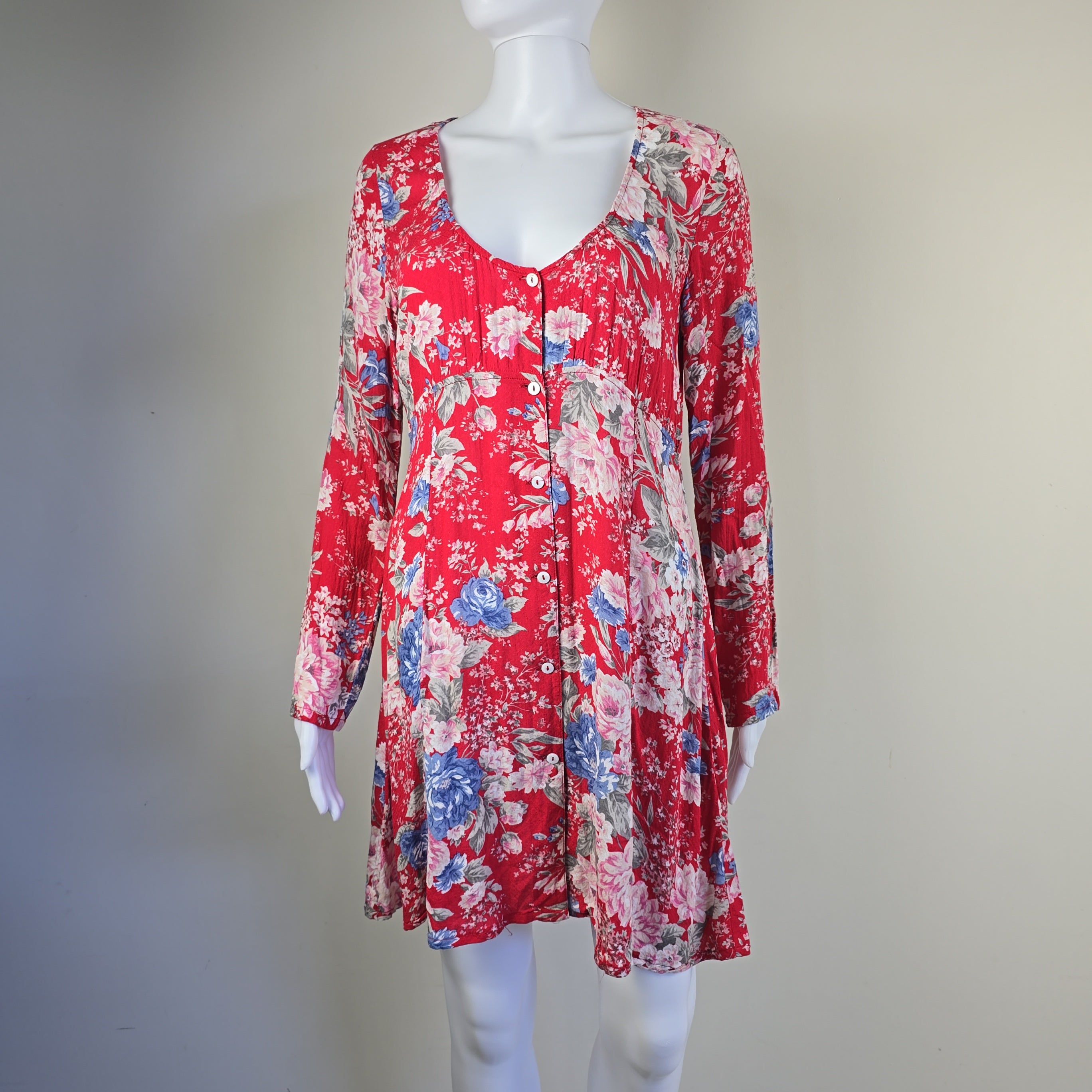 Red floral dress on a mannequin against a plain background