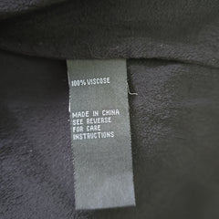 Fabric tag on black fabric with text about material and care instructions.