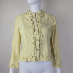 Light yellow ruffled jacket on a mannequin against a plain background