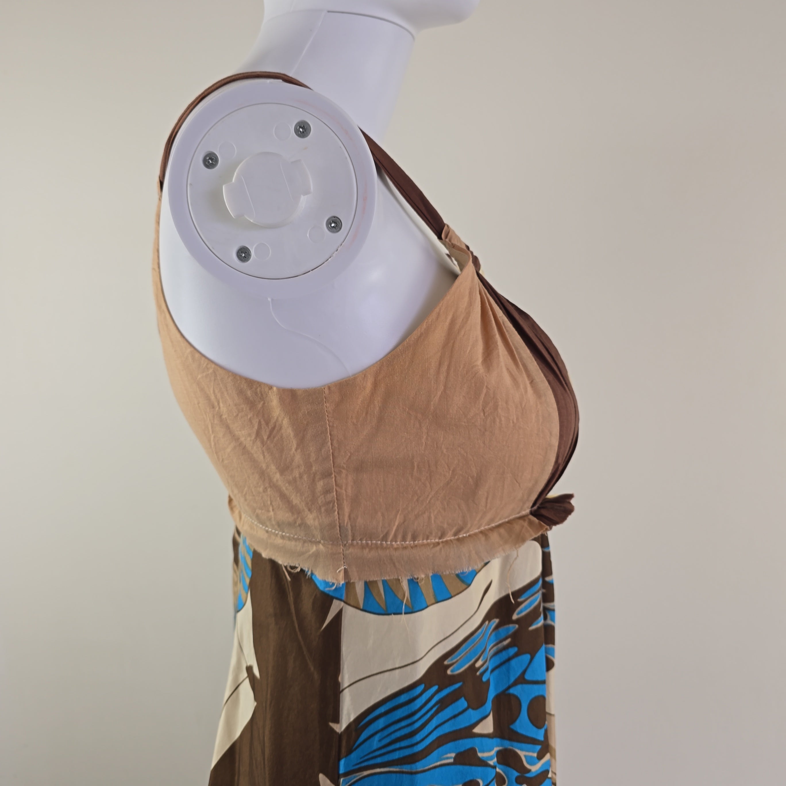 Mannequin wearing a patterned dress on a plain background