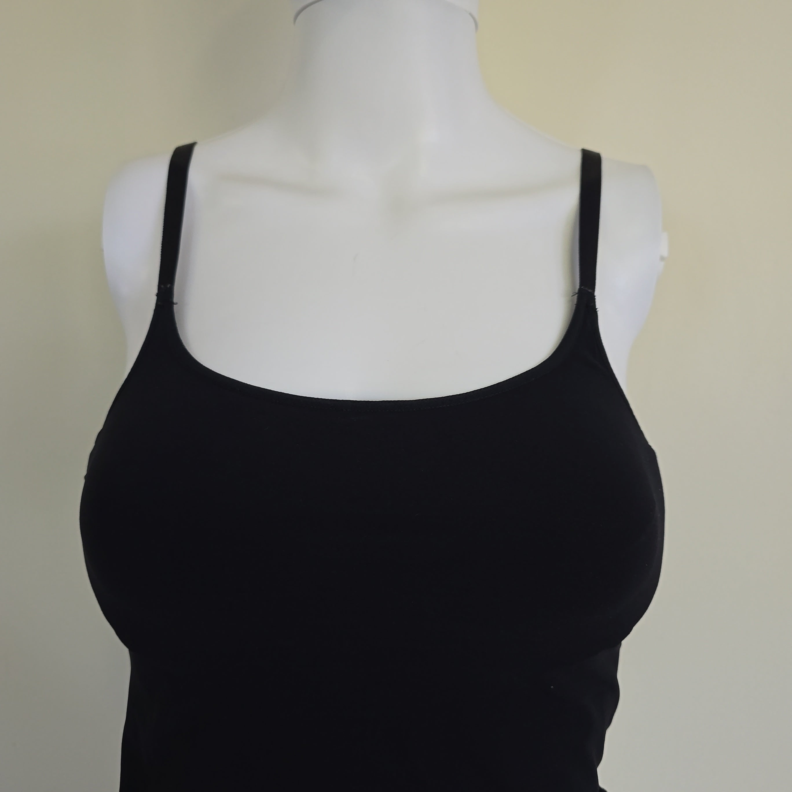 Black tank top on a mannequin against a beige background