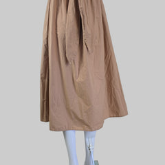 Brown dress against a white wall