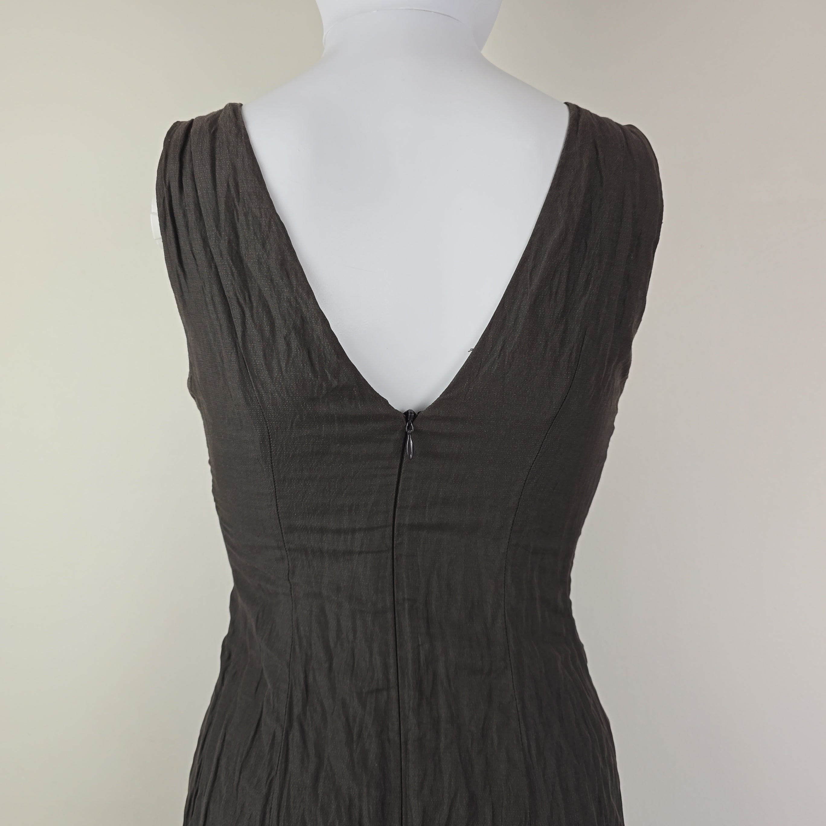 Black strapless dress on a mannequin with a plain background