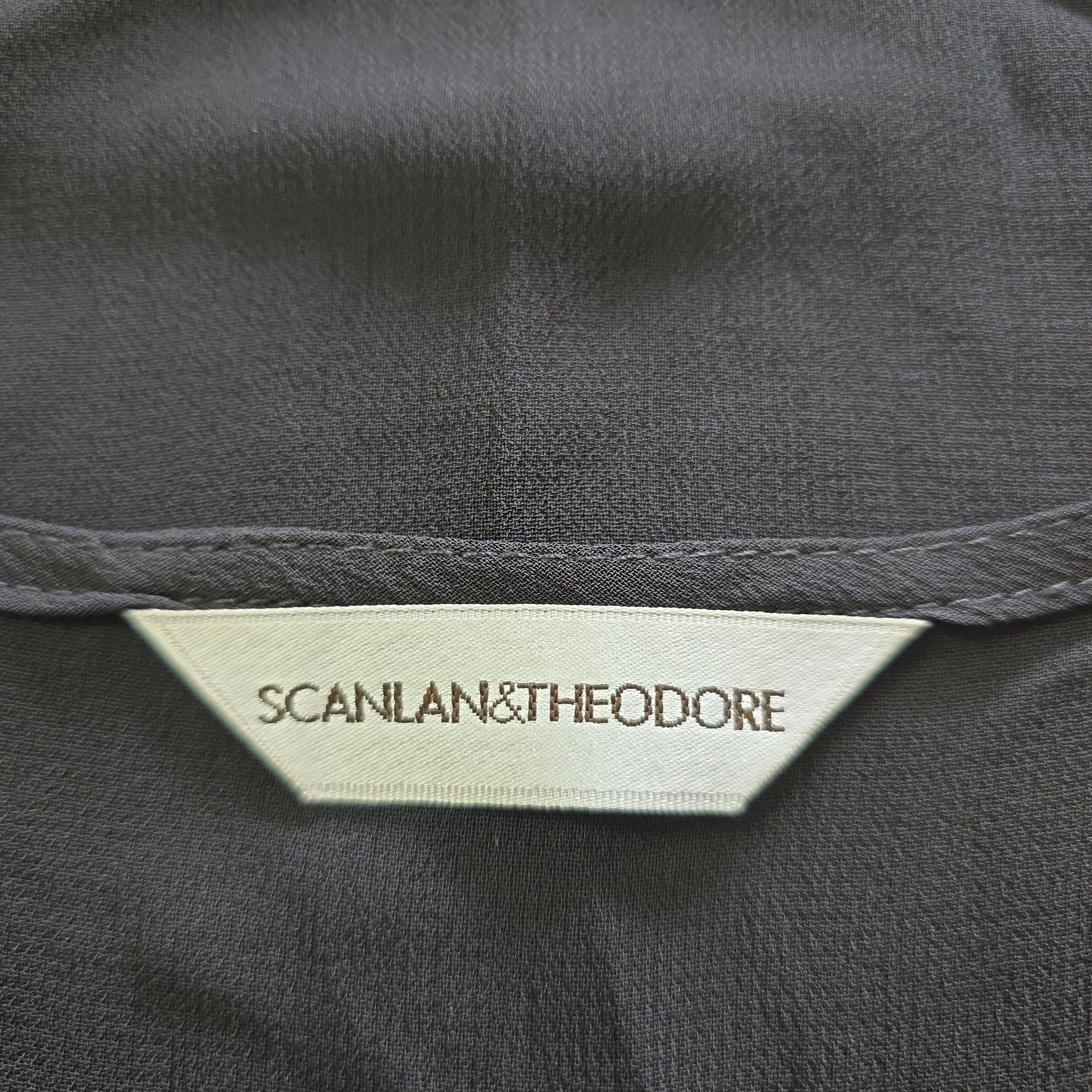 Close-up of a label on a dark fabric with 'SCANLAN & THEODORE' branding.