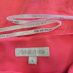 Close-up of a pink garment with 'Forever New' branding on a strap and label.