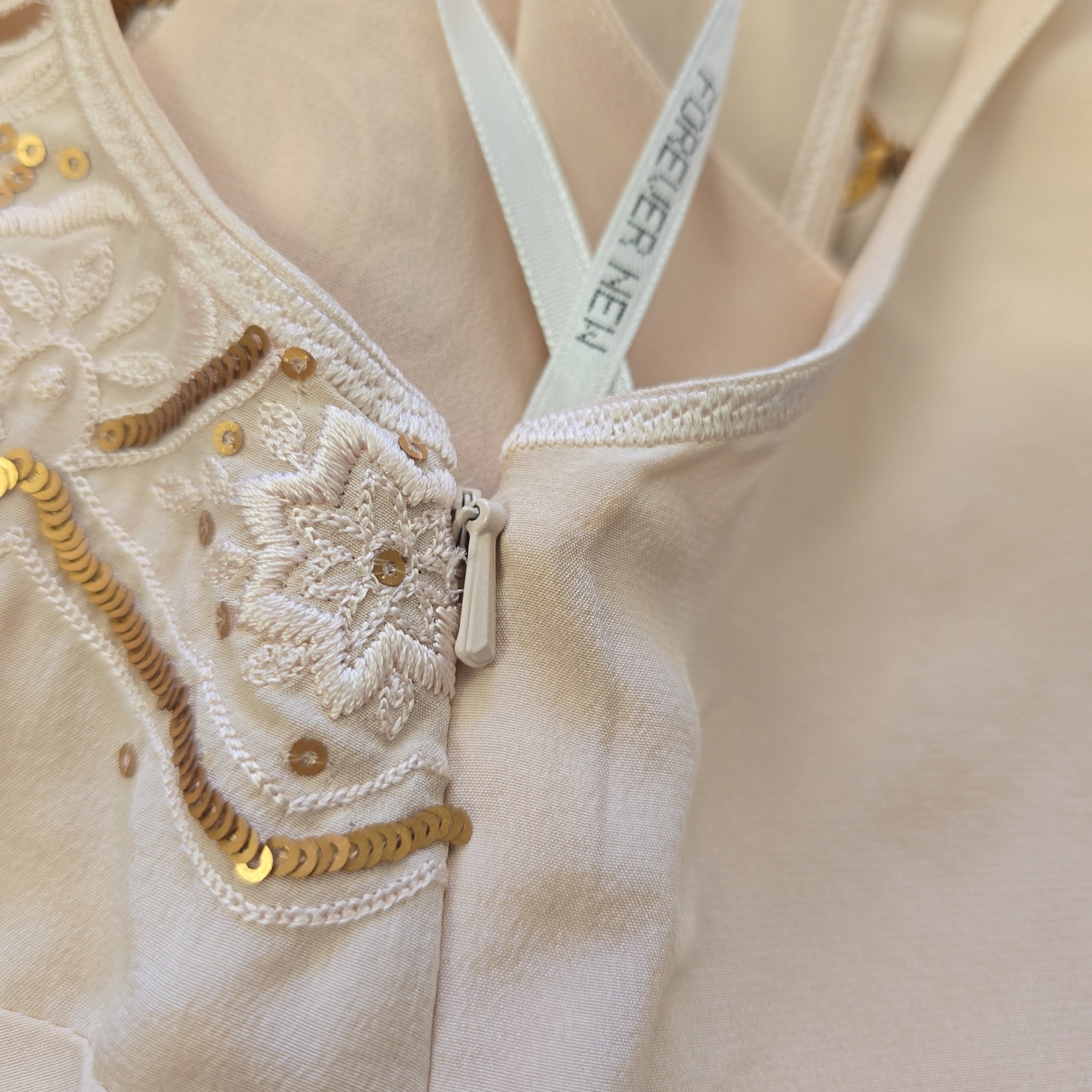 Close-up of a beige garment with lace details and 'Forever New' label.