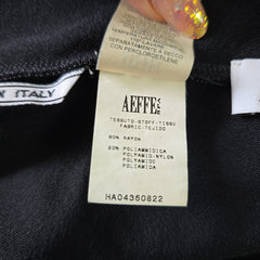 Close-up of a clothing label with 'Aeffe' branding on a dark fabric background.