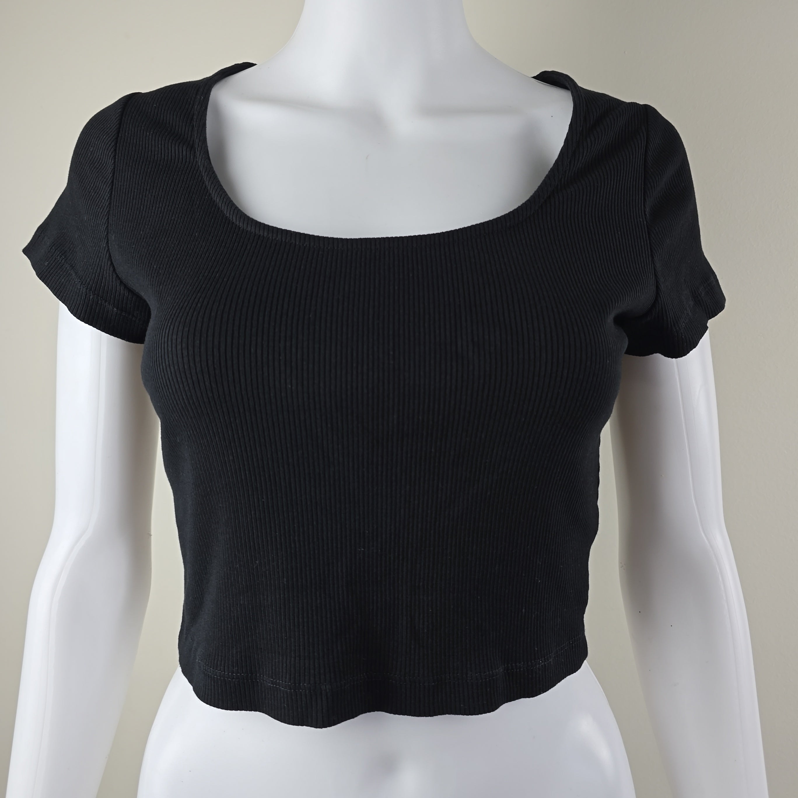 Black sleeveless top on a mannequin against a neutral background