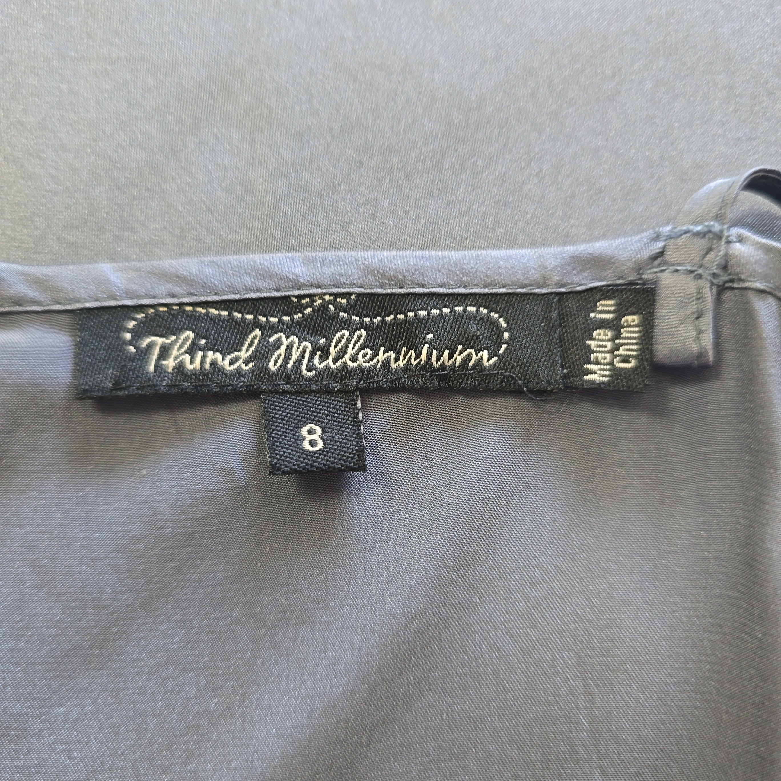 Label on a gray garment with 'Third Millennium' branding