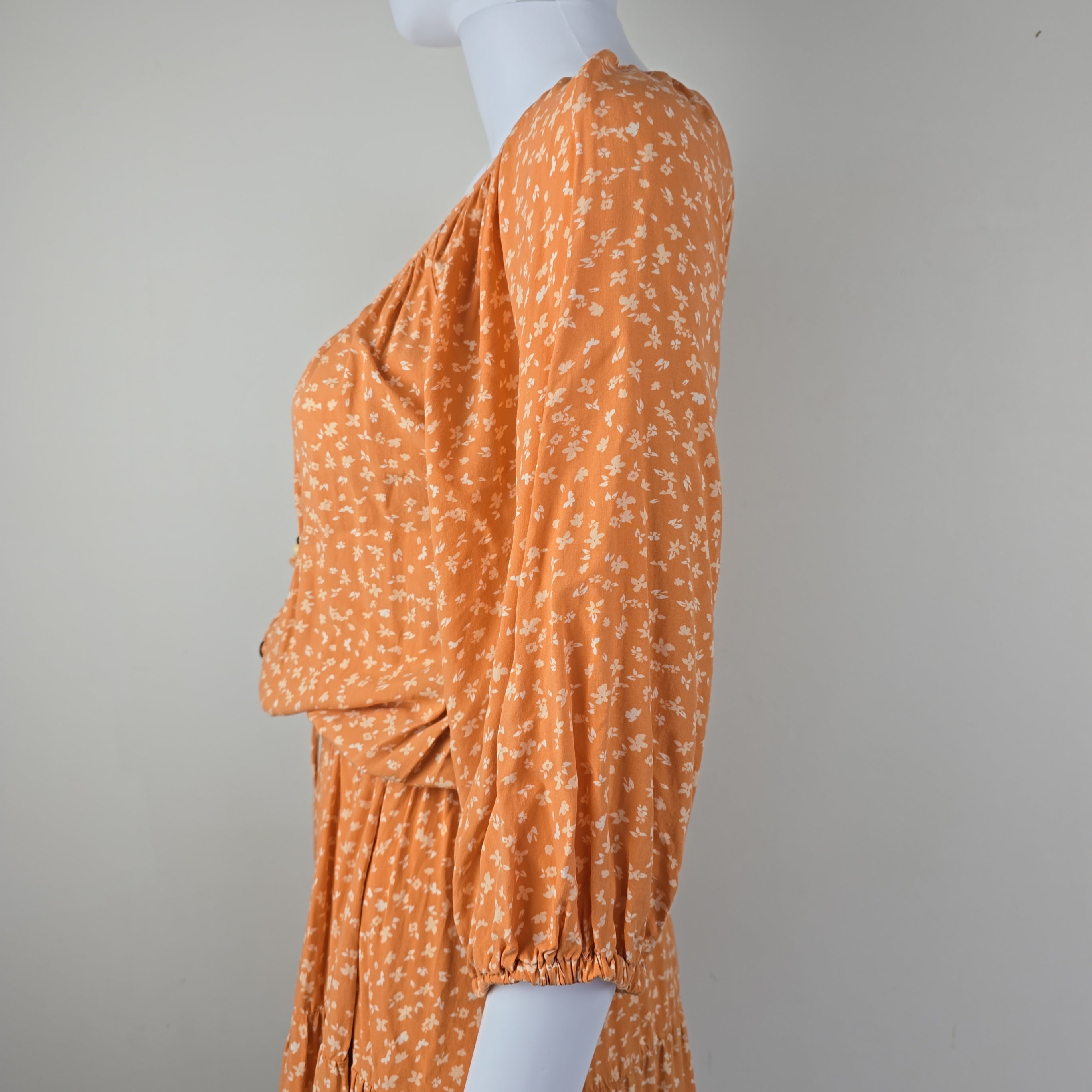 Orange floral dress on a light gray background