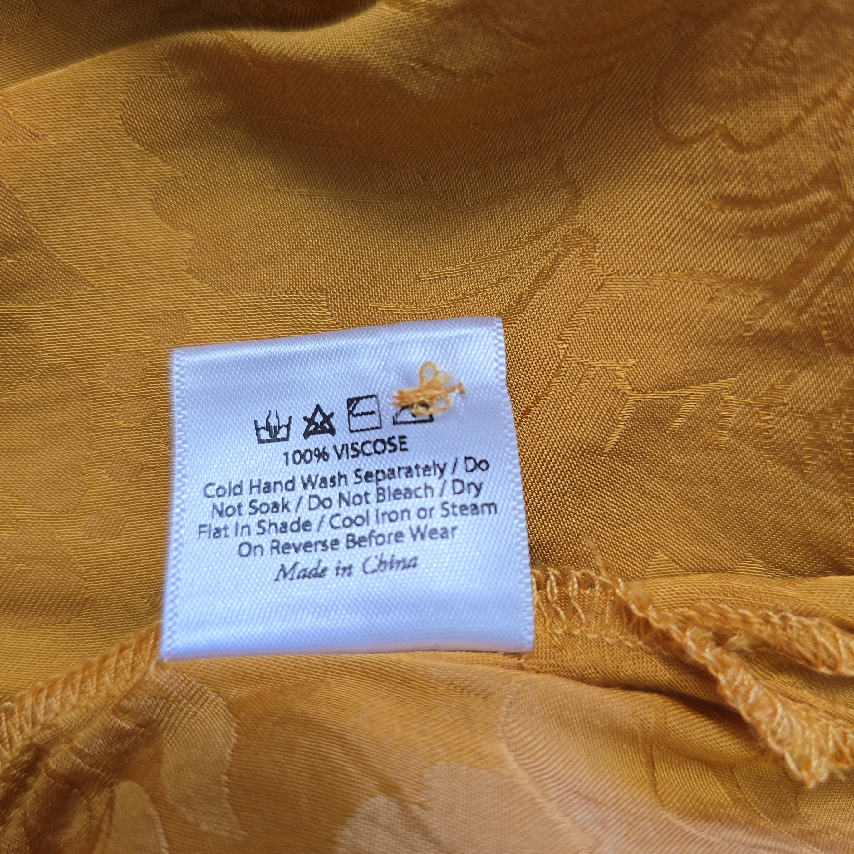 Clothing label on a yellow fabric background