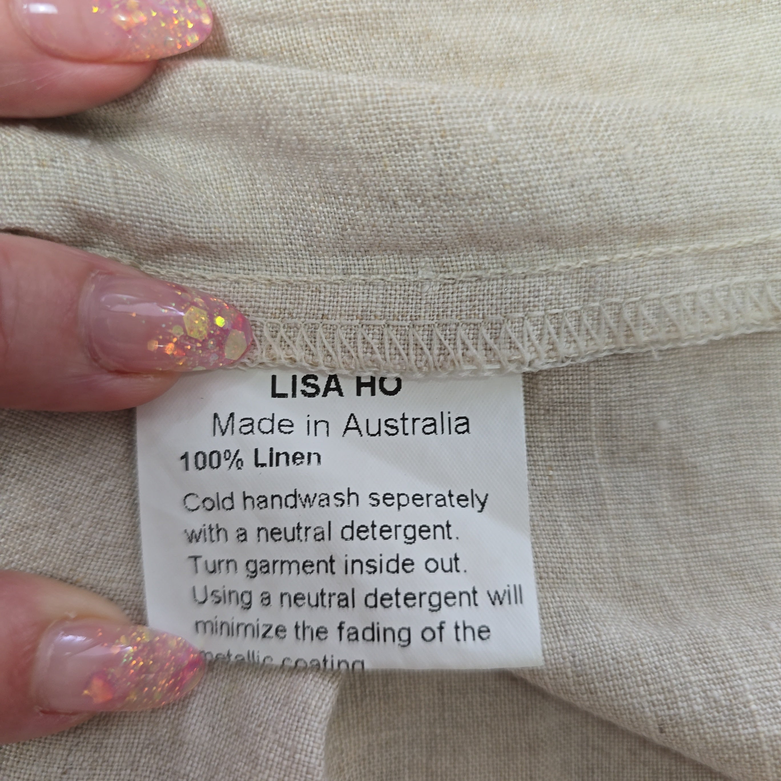 Fabric tag on beige linen fabric with 'Lisa Ho' branding