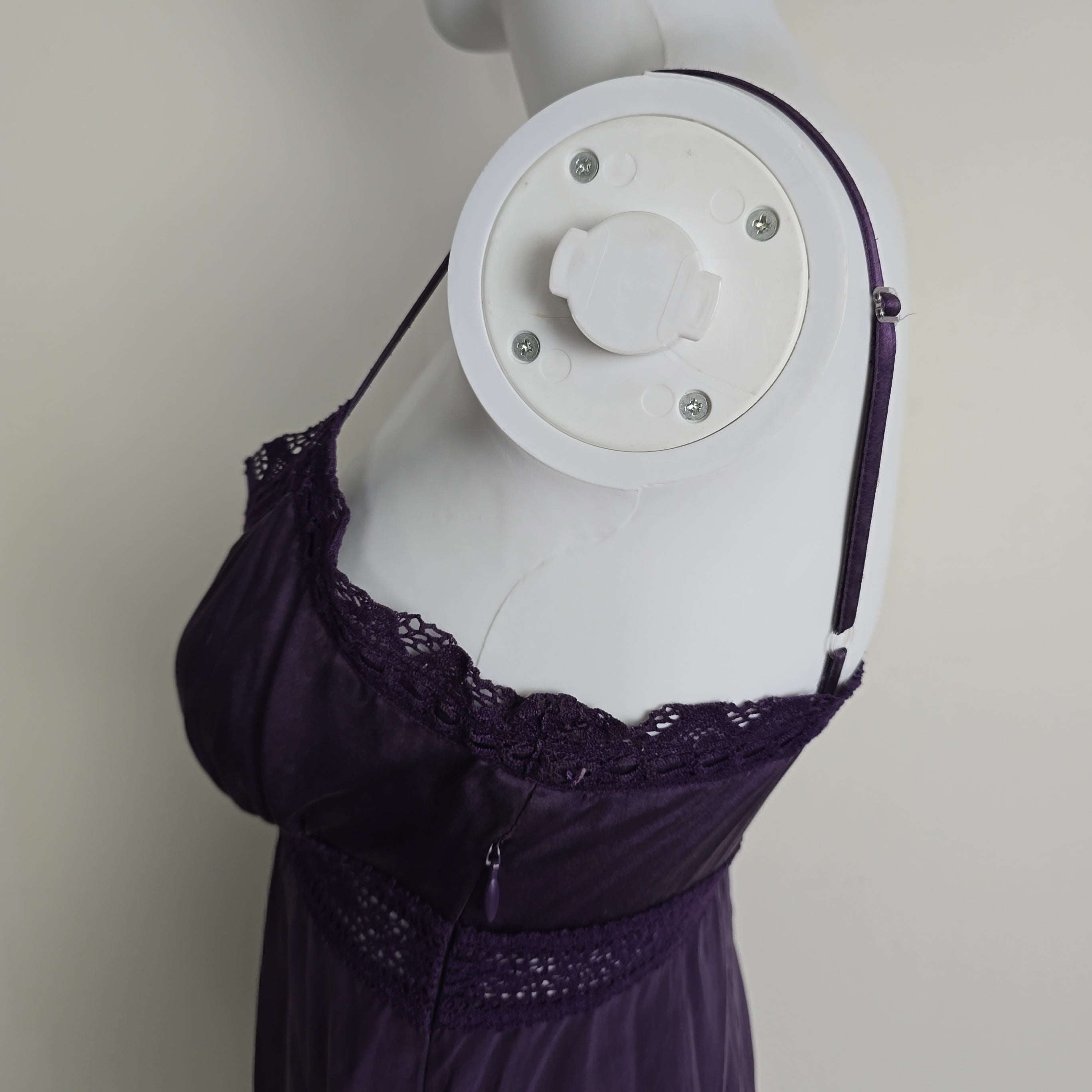 Mannequin wearing a purple lace top on a plain background