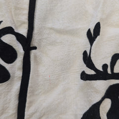 Black floral pattern on a textured white fabric background