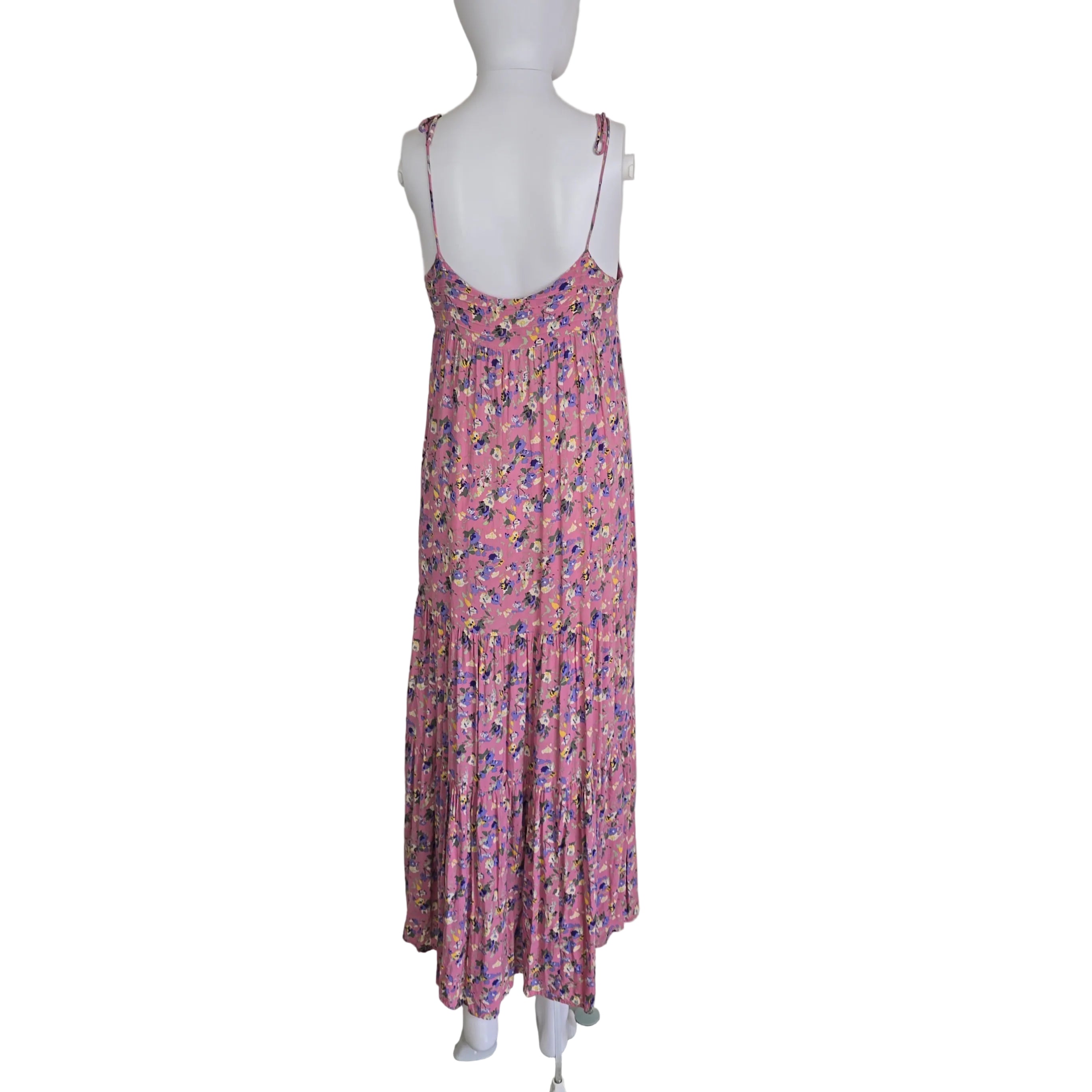 Pink floral dress on a mannequin against a white wall.