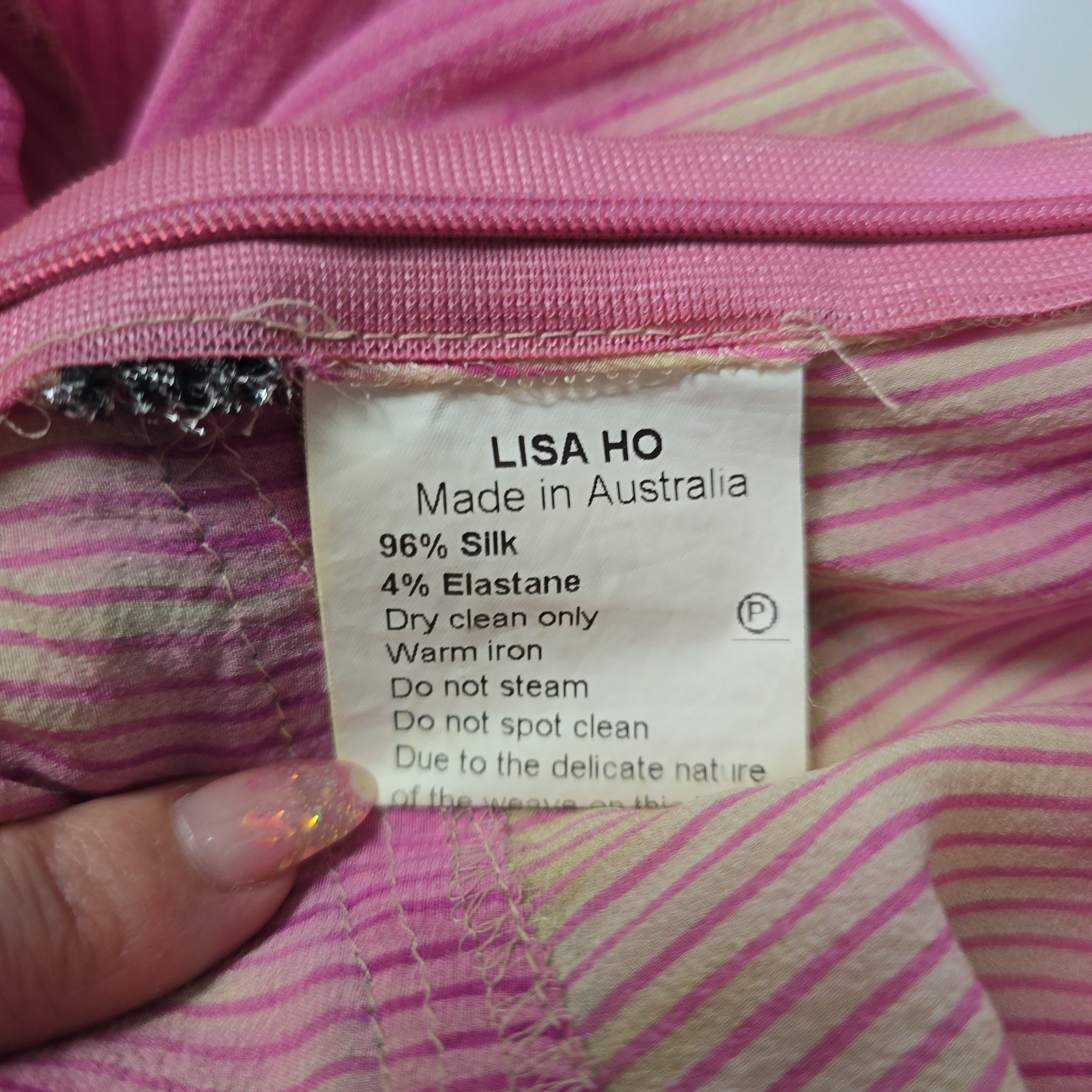 Close-up of a label on pink fabric with 'LISASHO' branding.