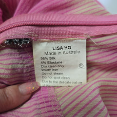 Close-up of a label on pink fabric with 'LISASHO' branding.