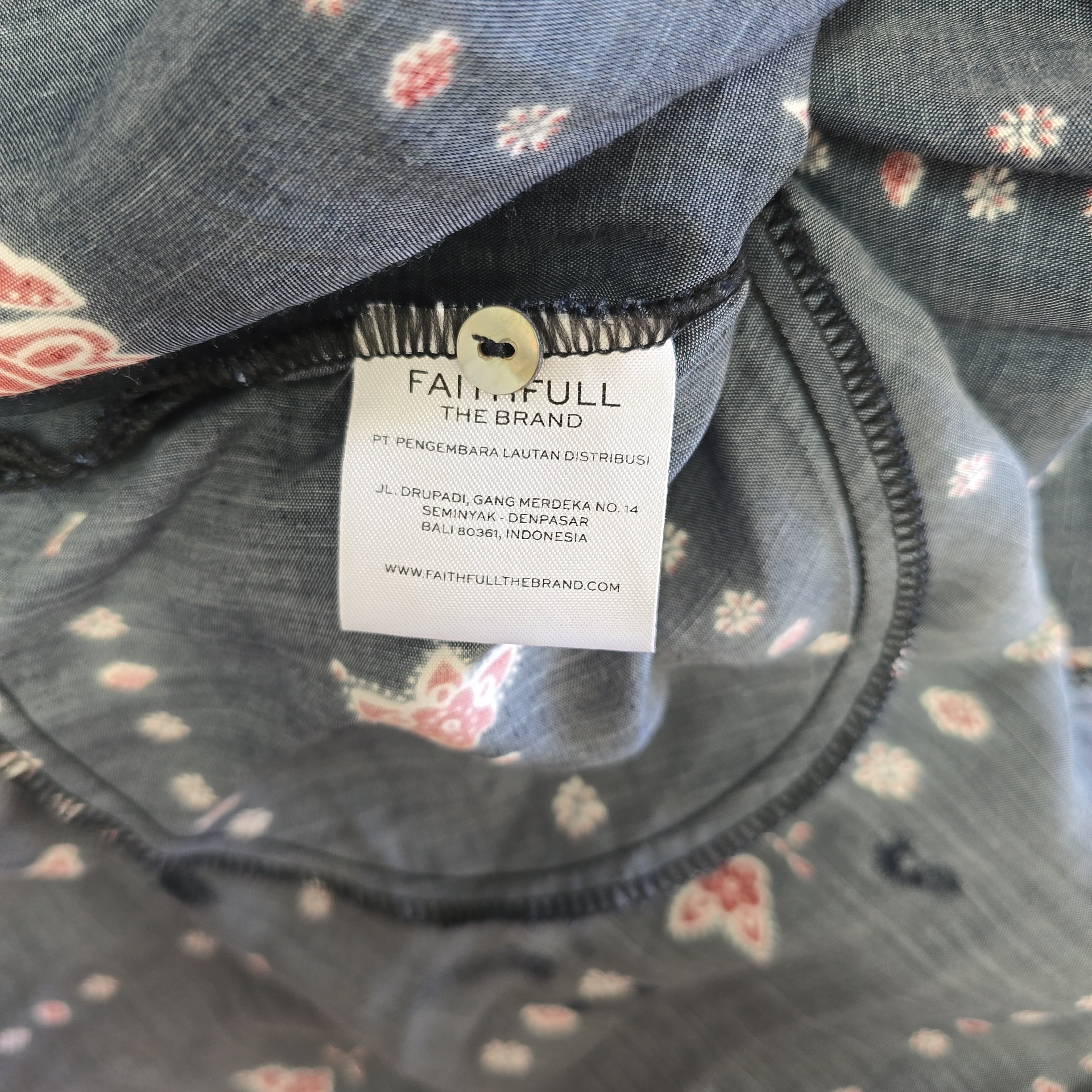 Close-up of a floral-patterned garment with a brand label.