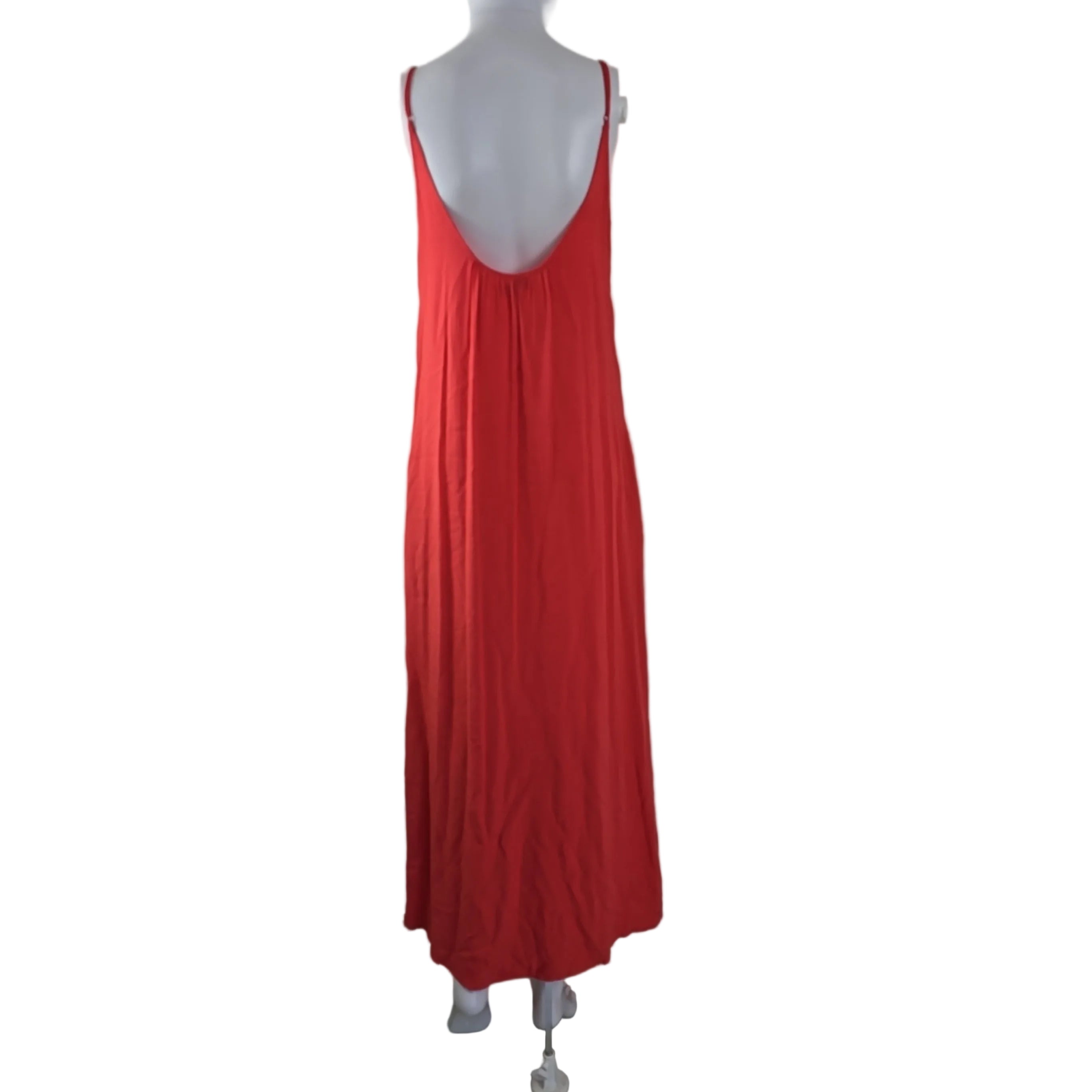 Red dress on a mannequin against a white wall.