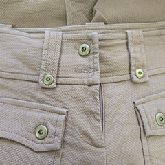 Close-up of beige fabric with buttons and zippers