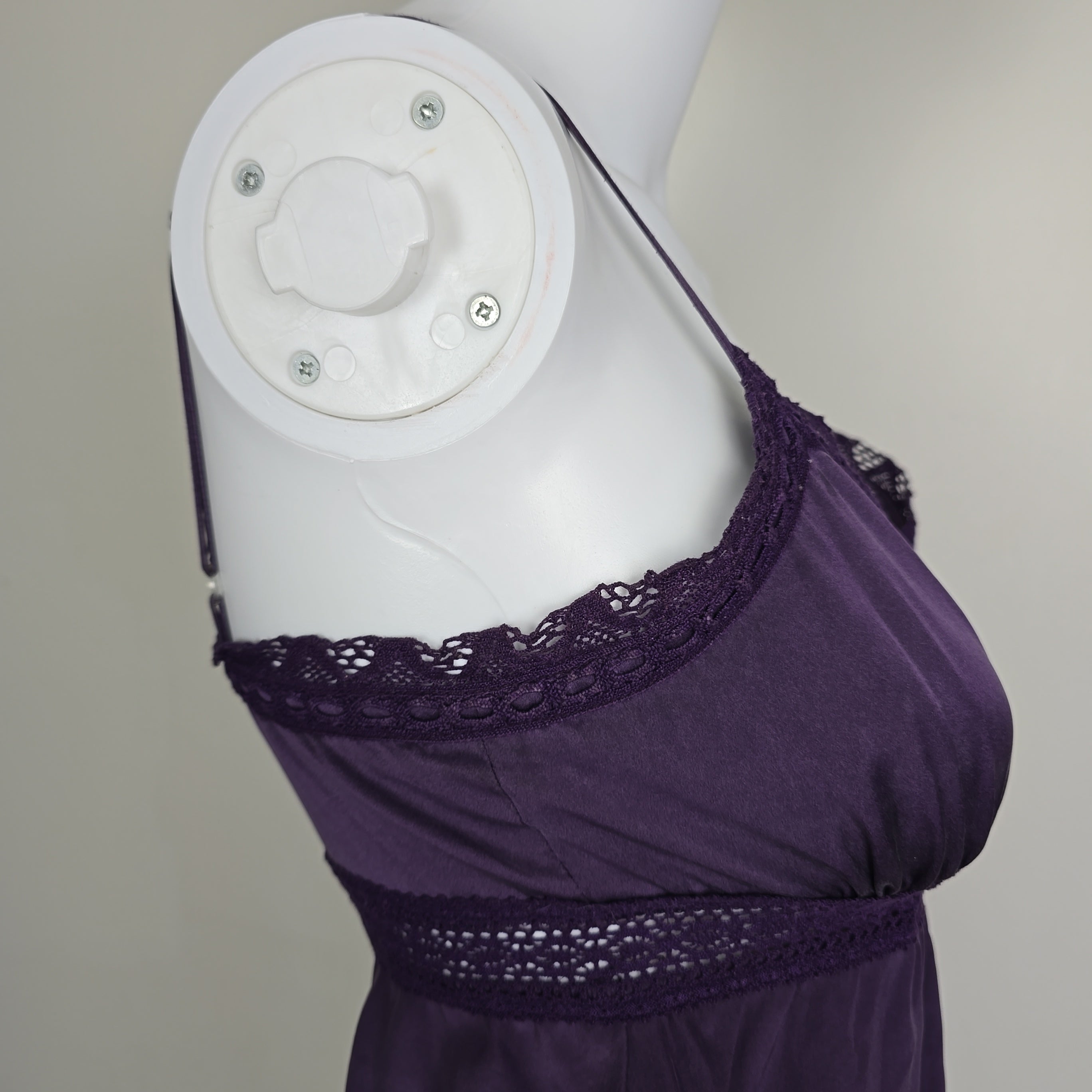 Purple lace-trimmed garment on a white mannequin against a neutral background