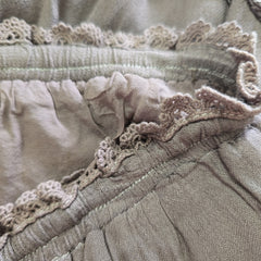 Close-up of textured fabric with lace detailing in neutral colors