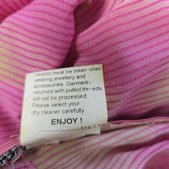 Close-up of a clothing tag on a pink striped garment with text.
