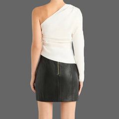 Person wearing a white top and black skirt with knee-high black boots on a white background