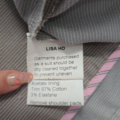 Label on a suit with 'Lisa Ho' branding and fabric care instructions.