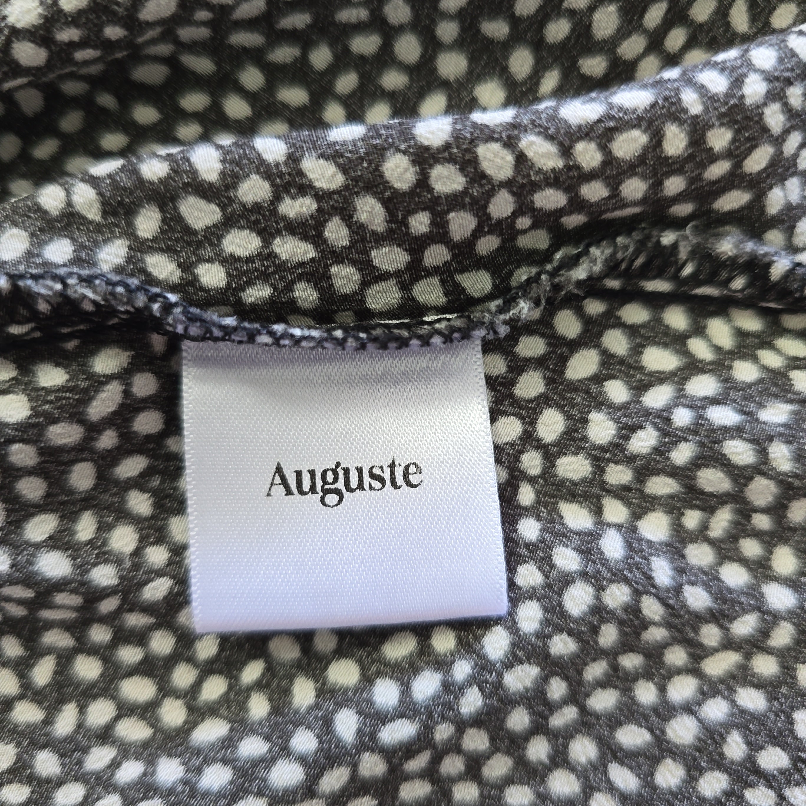 Fabric with a polka dot pattern and an 'Auguste' label.