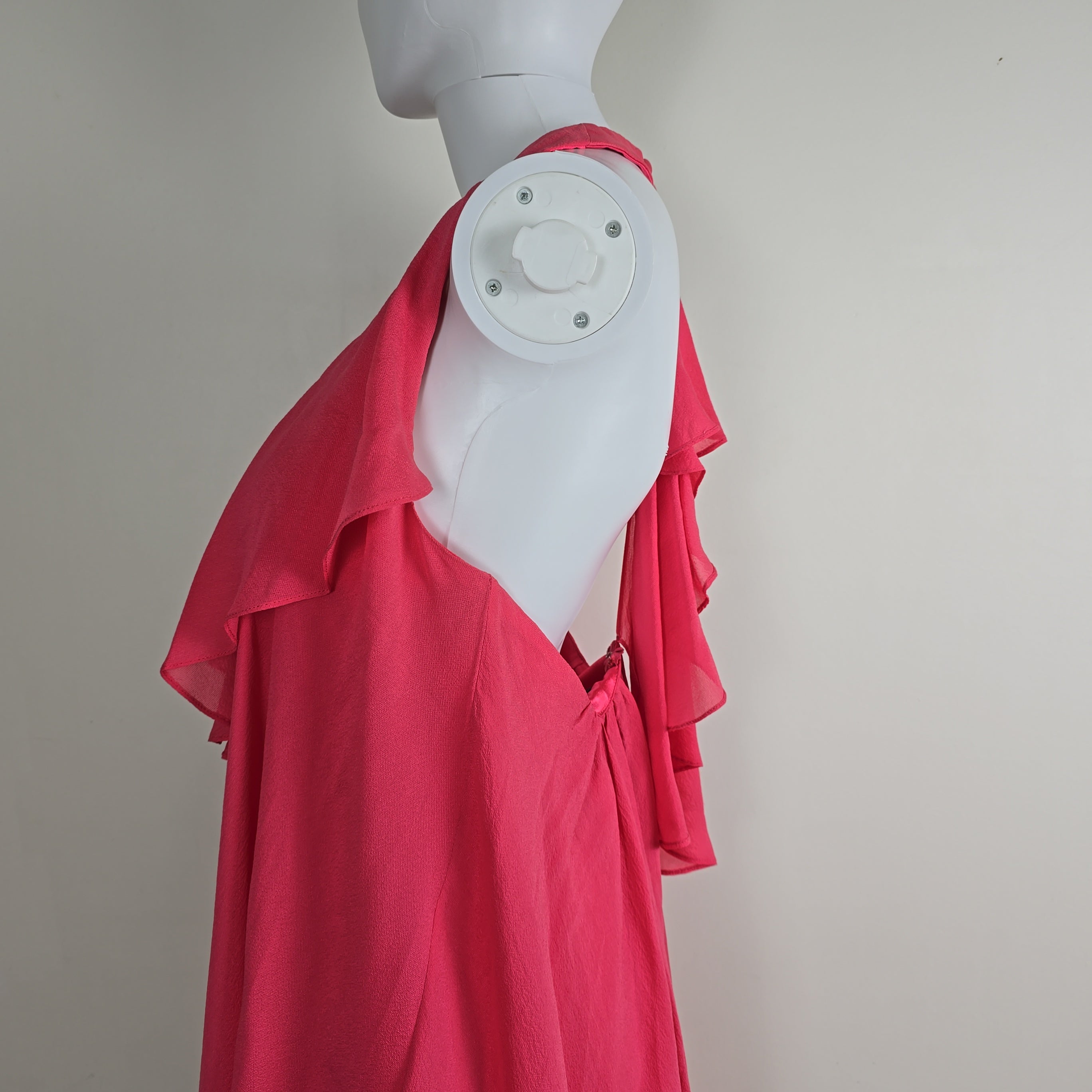 Mannequin wearing a red garment with a white base on a plain background