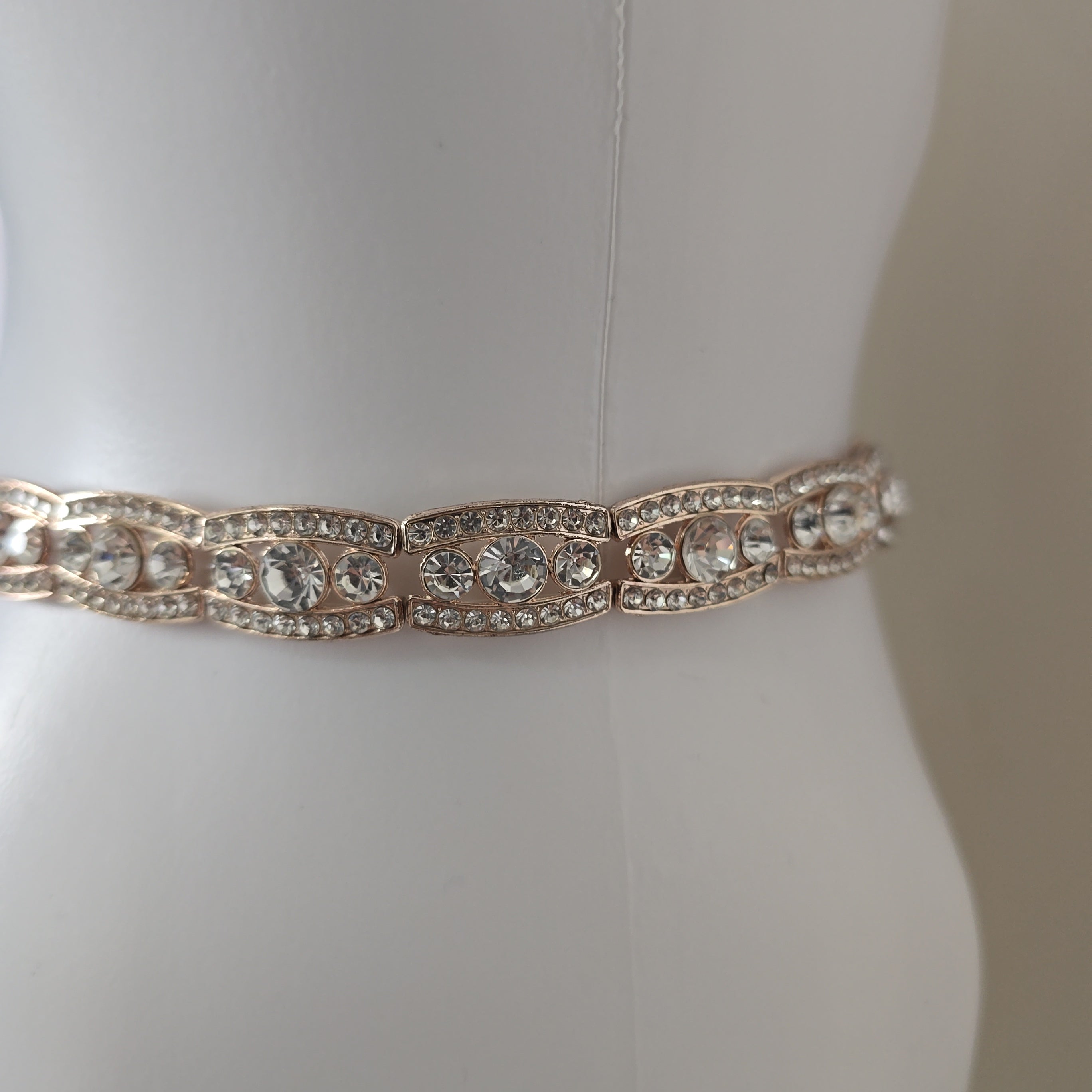 Rose gold belt on a mannequin against a white background